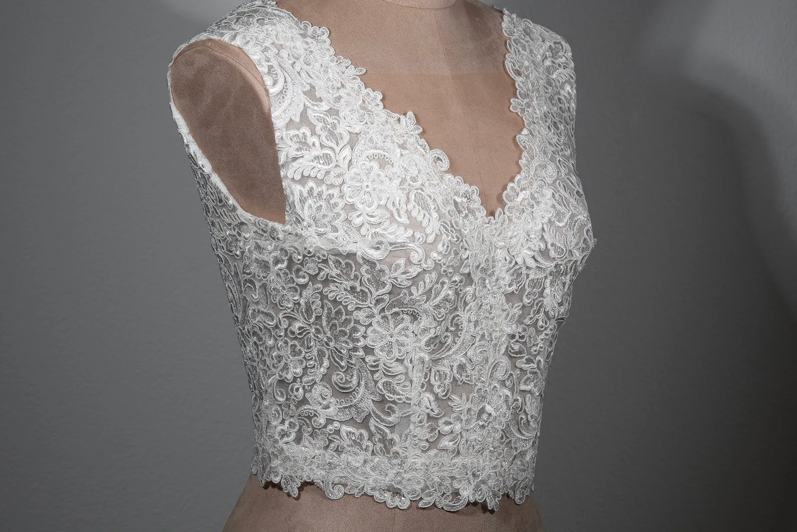 Brauttop „Luna“ von OlesJa aus bestickter Spitze in Champagne mit dezenten Pailletten, V-Ausschnitt vorne und hinten sowie transparentem Soft-Tüll.