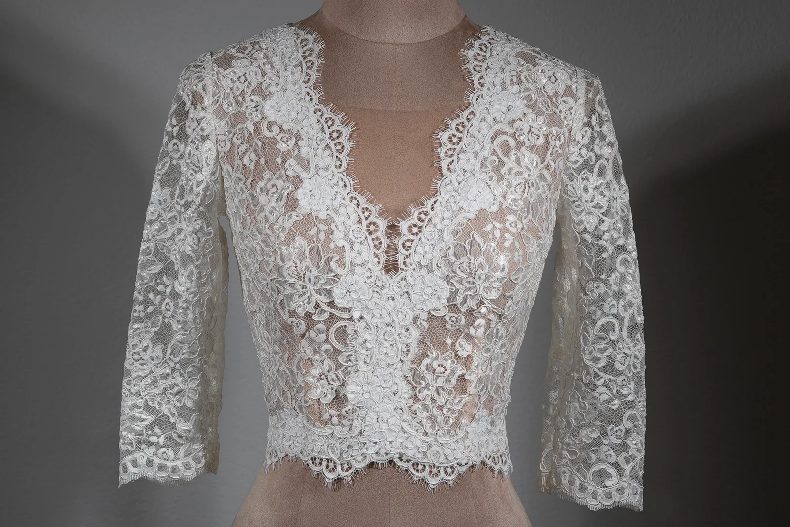 Brauttop Pearl von OlesJa aus weicher Spitze in Ivory mit 3/4-Ärmeln, V-Ausschnitt, hochgeschlossenem Rücken und Perlen-Imitationsknöpfen – elegantes Brautoberteil für moderne und klassische Brautmode.